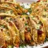 A plate of mini baked chicken tacos topped with fresh ingredients